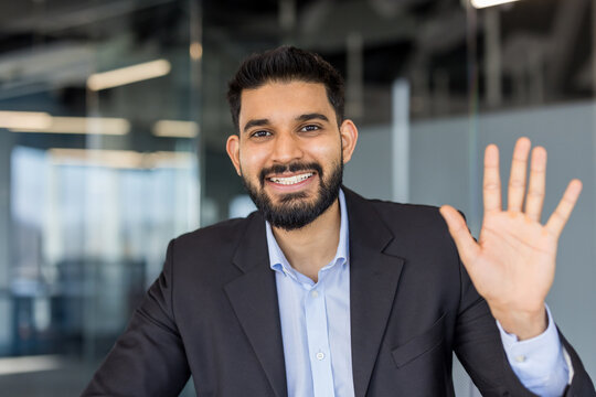 Businessman waving hand during video call in office