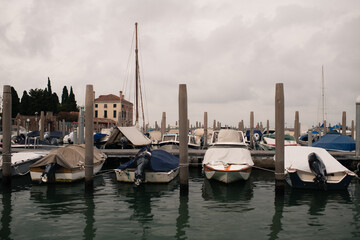 Weathered Venetian palaces and moored boats line the edge of a quiet canal in Venice, Italy. © Dillon T.