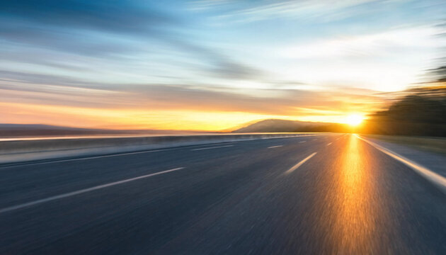 Empty asphalt road highway stretching into the distance at golden hour sunset