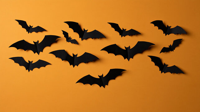 Paper bats flying across a festive Halloween-themed background, playful holiday decoration concept, with copy space