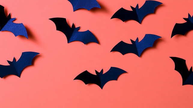 Paper bats flying across a festive Halloween-themed background, playful holiday decoration concept, with copy space