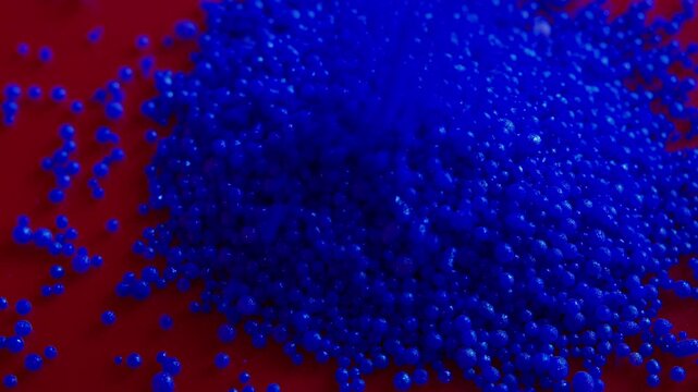 Close up of blue plastic pellets falling, showing raw material for injection molding. Great for petrochemical industry, polymer manufacturing, and modern science videos.