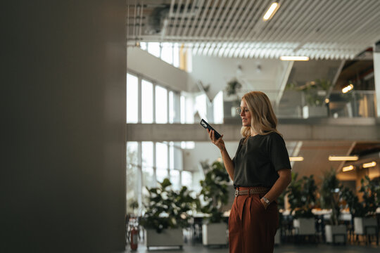 Businesswoman talking on smartphone in modern office building