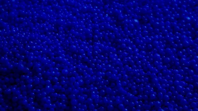Macro view of many blue plastic particles , abstract raw material background