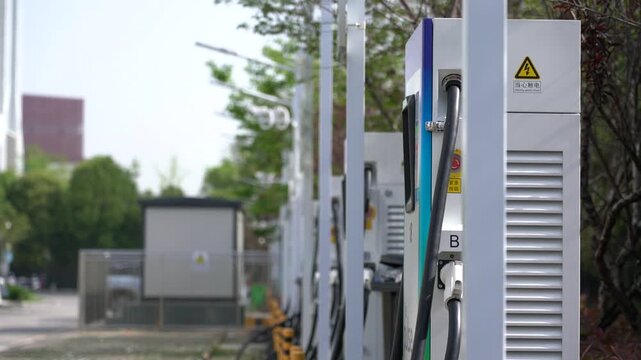 Row of Electric Vehicle Charging Stations with Cables and Bollards Outdoors