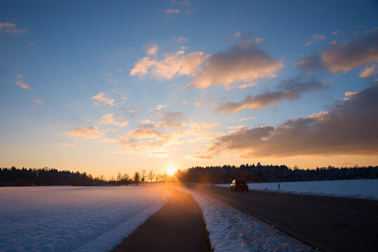 bike way beside the country road. winter landscape at sunset