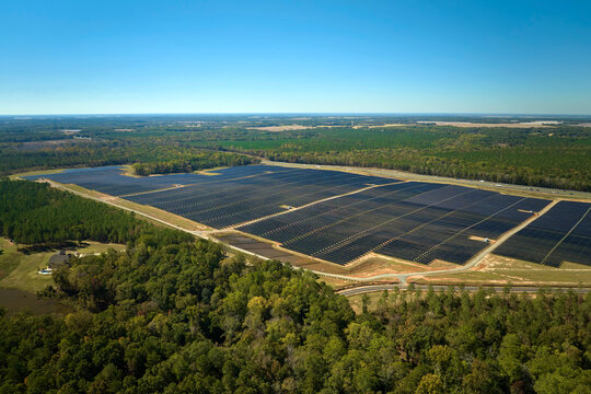 Aerial view of big sustainable electric power plant with many rows of solar photovoltaic panels for producing clean electrical energy. Renewable electricity with zero emission concept