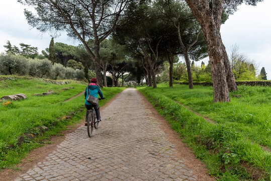 Young Woman Cycling on Via Appia Antica, Rome