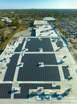 Aerial view of many photovoltaic panels installed on shopping mall roof top for producing of green ecological electricity. Production of sustainable energy concept