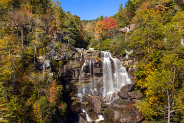 Obraz premium Beautiful waterfall landscape. Autumn view of Whitewater Falls. Water flows through colorful forest in Nantahala National Forest.