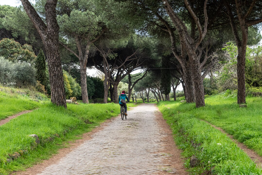 Young Woman Cycling on Via Appia Antica, Rome