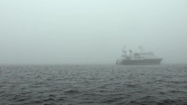Arctic Ocean Ship Crossing Dark Polar Waters in the Far North. Dark swells move across the cold water while the distant polar horizon remains clearly visible. Remote Arctic atmosphere remains clear.