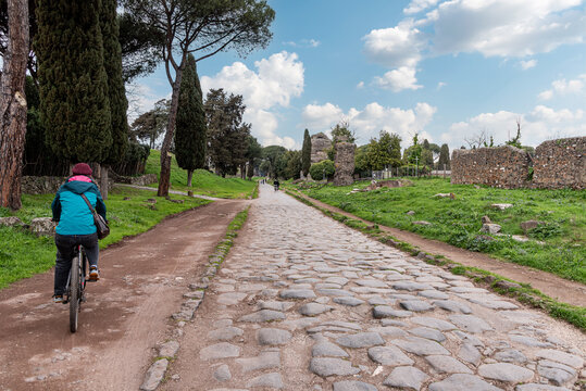 Young Woman Cycling on Via Appia Antica, Rome