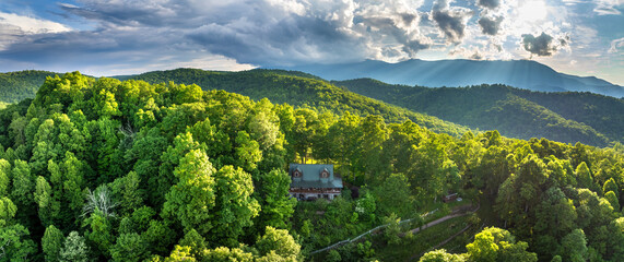 Large wooden house on mountain side near Mount Mitchell in North Carolina Blue Ridge Mountains. Travel destination in USA. Colorful sunset in wild mountains. Beautiful nature landscape © bilanol