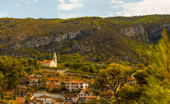 Historic Church and Village Beneath Rocky Hills in a Mediterranean Landscape