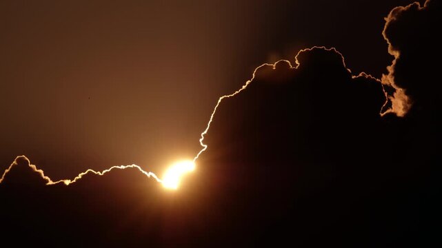 The Sun hides in the forming cumulonimbus cloud