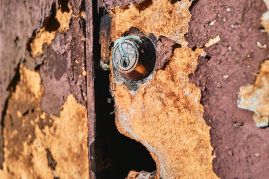 Old Door Lock With Severely Peeling Paint and Weathered Wood