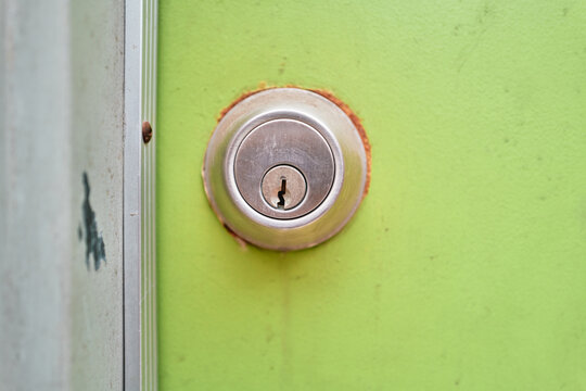 Silver Deadbolt Lock on a Lime Green Painted Door