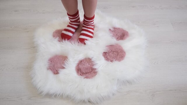 Teenager girl wearing funny striped socks touching fluffy carpet and enjoying its softness and warmth. The plush carpet felt silky smooth under my feet, making every step a joy.