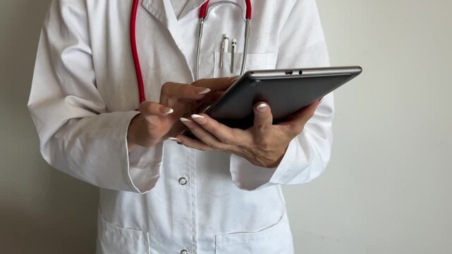 Veterinaria con bata llena de pelo consultando una tablet