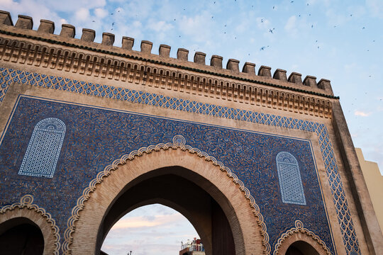 Architectural close-up framing the intricate blue ceramic mosaic tilework and monumental horseshoe arch of the historic Bab Bou Jeloud gate in Fes, Morocco