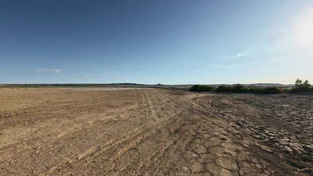 Forward tracking shot over cracked arid mud flat