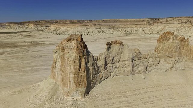 Aerial view circling a large desert rock formation