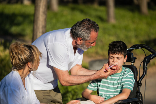Healthcare professionals giving medication to child with cerebral palsy