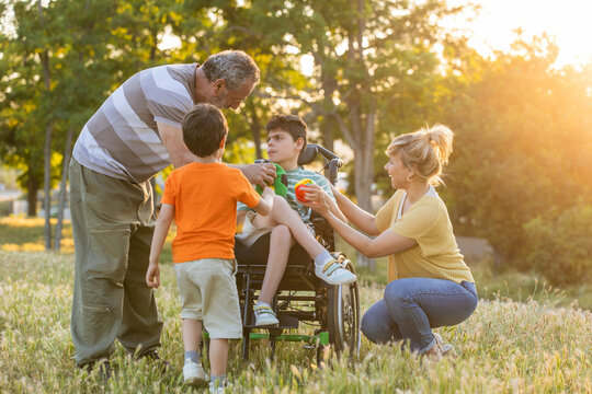 Family enjoying park time with son in a wheelchair