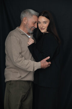 Older man embracing his granddaughter in a tender family portrait. The intimate moment represents intergenerational love, trust, emotional connection, and a strong family bond.