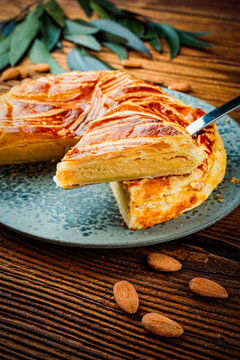 Classic traditional artisan homemade french galette des rois - three kings cake served as close-up on a design plate on wooden board