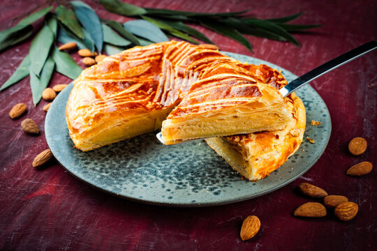 Classic traditional artisan homemade French galette des rois - three kings cake served as close-up on a design plate on a wooden table