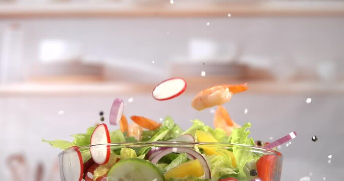 Shrimp falling onto fresh vegetable salad in slow motion
