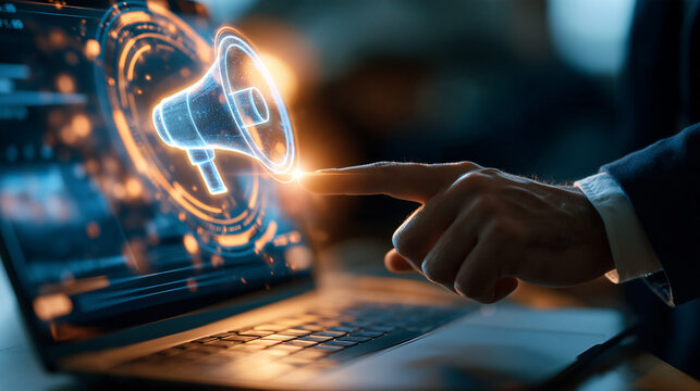 Businessman hand touching a laptop screen with a holographic megaphone icon european businessman hand cropped at the wrist glowing megaphone hologram hovering above an open laptop in