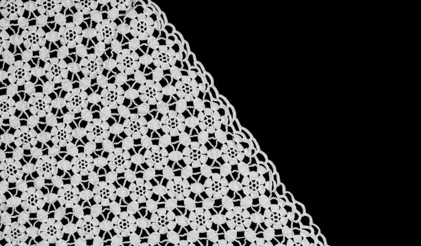 Crochet lace patterns border, crocheted Grandma's Doily, detail of hand-crocheted embroidery, tablecloth, napkin isolated on black background border art design. Craft, vintage linen. Flat lay. 