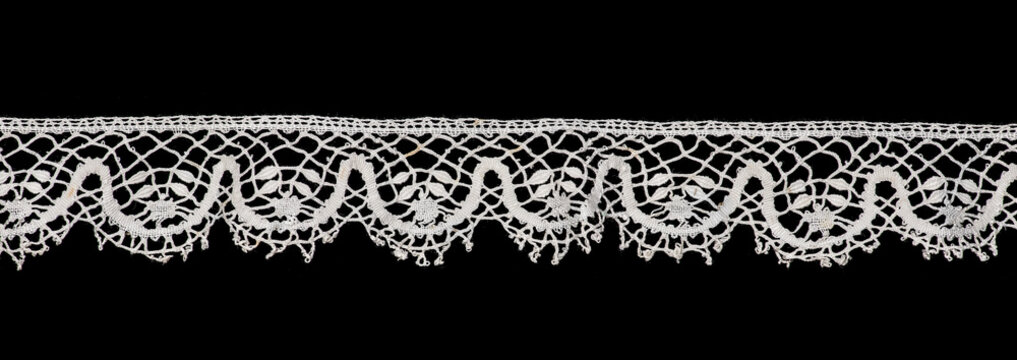 Bobbin lace tape isolated on black background, bobbin lace with gimp trim, vintage textile design, antique fabric art, doily. 
