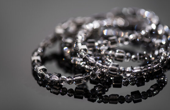 Crystals bracelet or necklace, gems, diamonds over black background, beautiful gems, rhinestones, brilliants sparkling with colorful rainbow lights. Moissanite. Zirconia. Border design. 