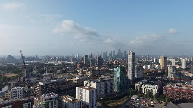 Aerial view of the Stratford and Canary Wharf skylines over East London rooftops and construction cranes
