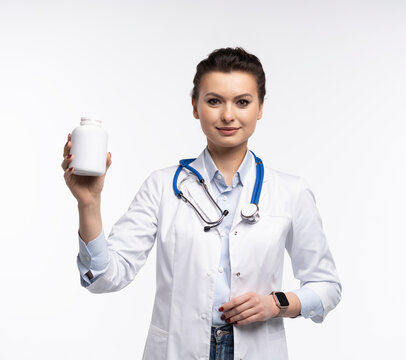 Attractive woman qualified specialist therapist wear white doctor robe hand hold pills isolated on white background.