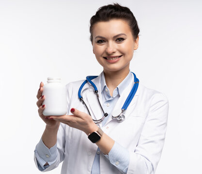 Attractive woman qualified specialist therapist wear white doctor robe hand hold pills isolated on white background.