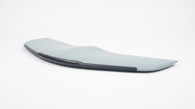 Sleek aerodynamic grey vehicle spoiler wing featuring smooth curves and modern metallic finishes in studio lighting
