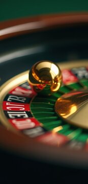 Gold ball rests on a roulette wheel. Concept of lottery, luck themed ads, fortune, destiny articles, entertainment venue posters, casino promotion banners, and online roulette game backgrounds.