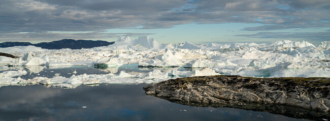 Climate Change conceptual photo. Global warming - Greenland Iceberg landscape of Ilulissat icefjord with giant icebergs. Icebergs from melting glacier. Arctic nature heavily affected by climate change © Maridav