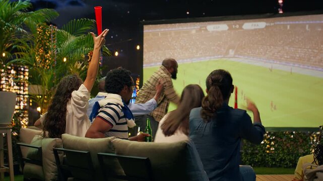 Energetic football supporters cheer for favorite team on rooftop