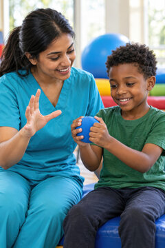 Eine Pflegekraft unterst&uuml;tzt ein Kind bei einer &Uuml;bung in der Kinderphysiotherapie. Die geduldige Begleitung f&ouml;rdert Bewegung, Entwicklung und Selbstvertrauen w&auml;hrend der Rehabilitation.