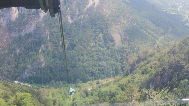 View of a dense forest while moving with a cable car to the Raxalpe in Austria