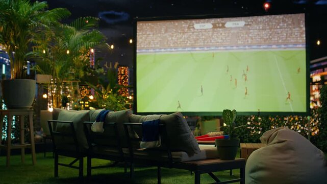 Large projection screen showing football match in rooftop lounge