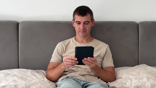 Man Reading an Ebook While Relaxing at Home, Front View