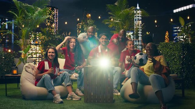 Cheerful football supporters react to live rooftop soccer match