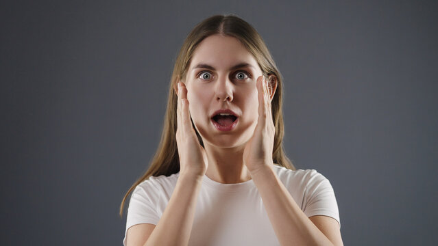 Young woman showing wide eyes and open mouth in surprise and disbelief